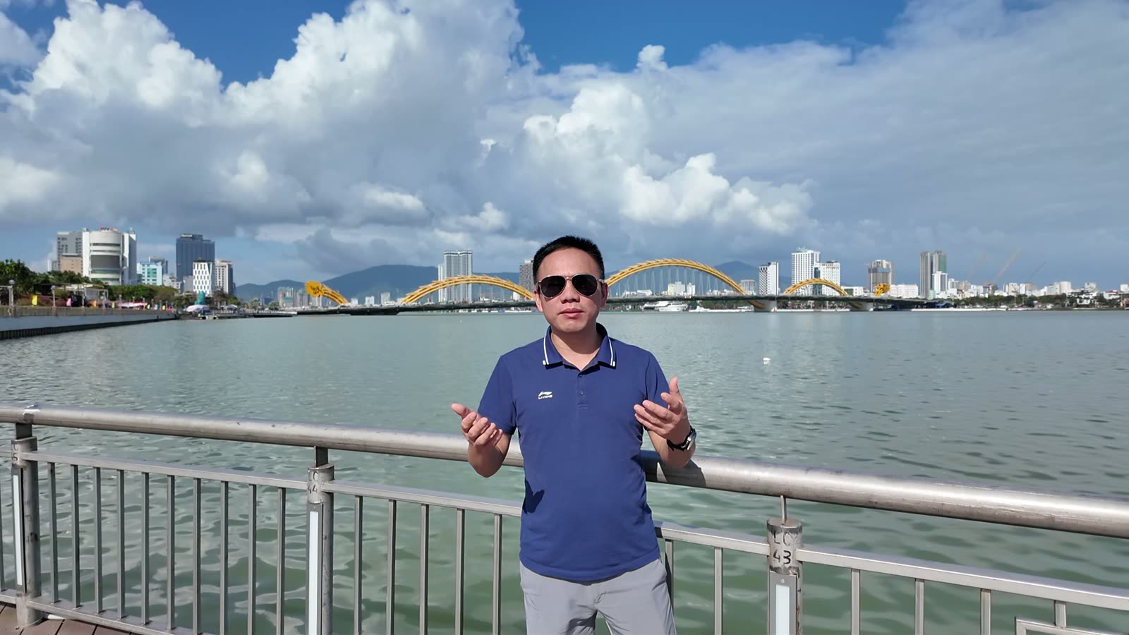 Mai Tien Tan beside the Han River in Da Nang, with the Dragon Bridge behind, on a clear January afternoon