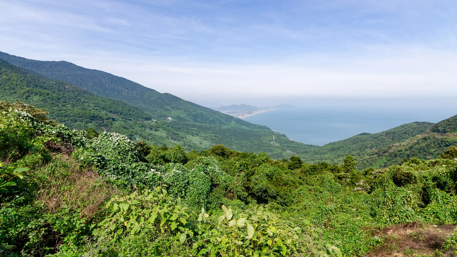 View from the Hai Van Pass over forested hillsides to the sea and the coast near Lang Co