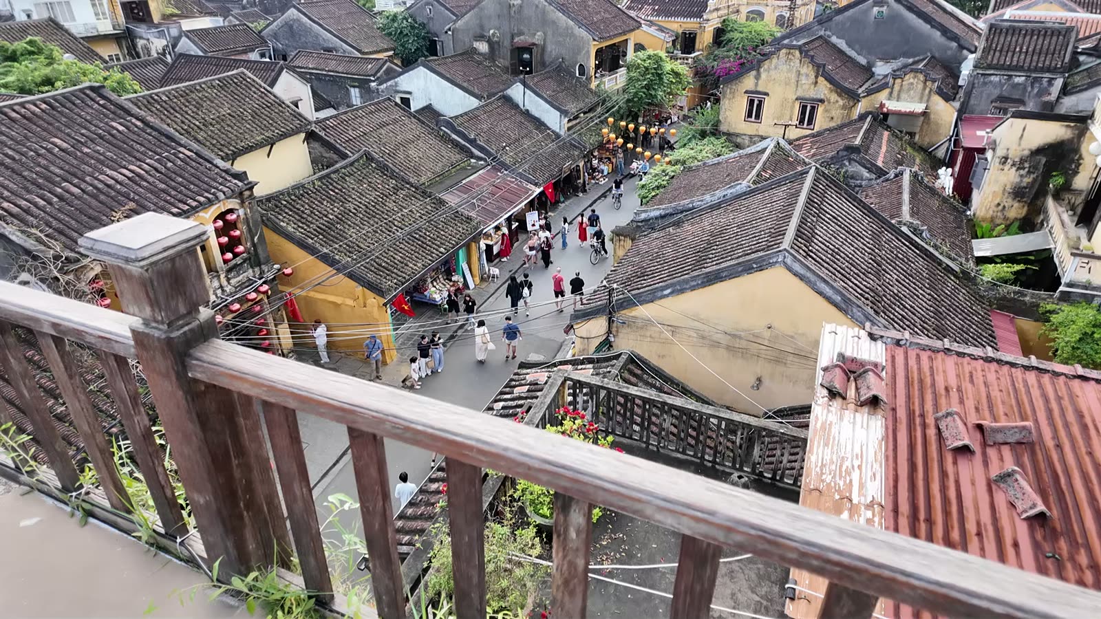 A street in Hoi An Ancient Town seen from a rooftop, above the tiled roofs