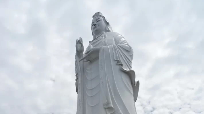 The white Lady Buddha statue at Linh Ung Pagoda on the Son Tra Peninsula, seen from below against cloud