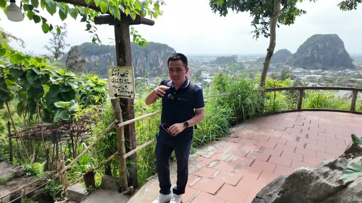 Mai Tien Tan at the summit viewpoint on Thuy Son at the Marble Mountains, with the other marble hills and Da Nang behind